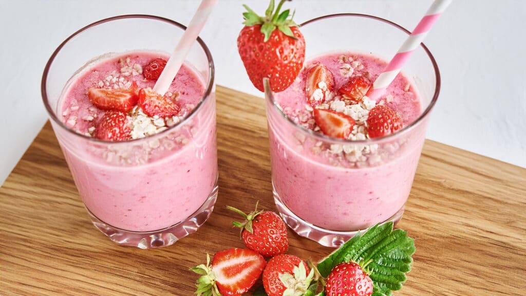 Smoothie de morango com aveia: duas taças de smoothie de morango com morangos e hortelã. Rico em proteínas e antioxidantes.